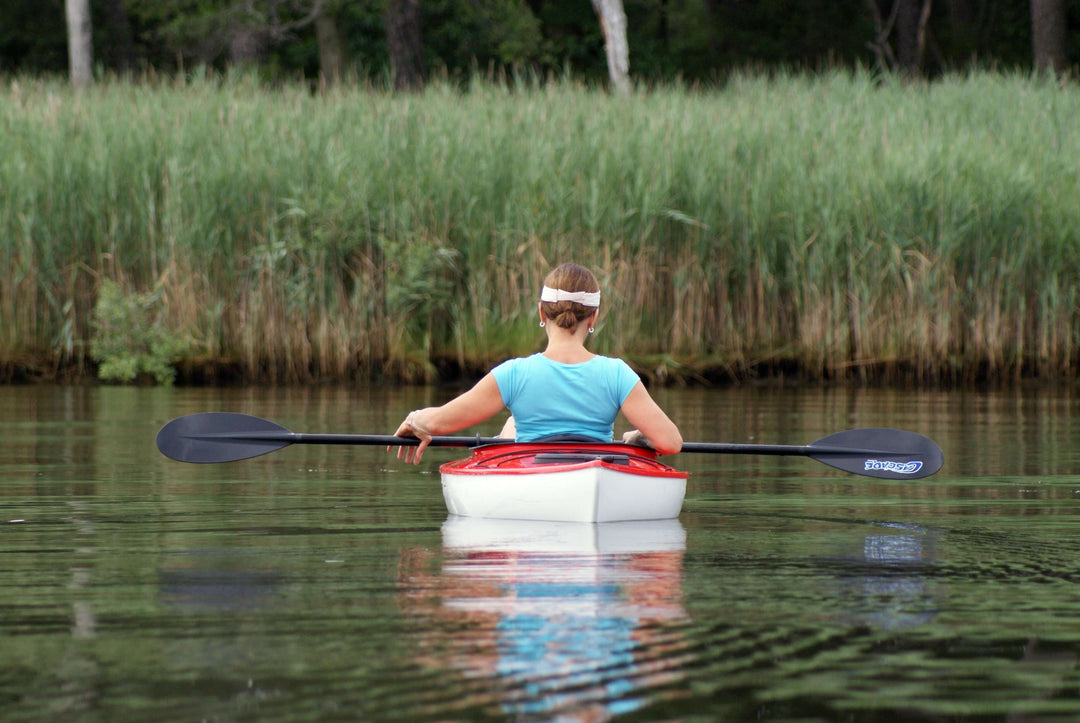 a woman kayaking on calm water