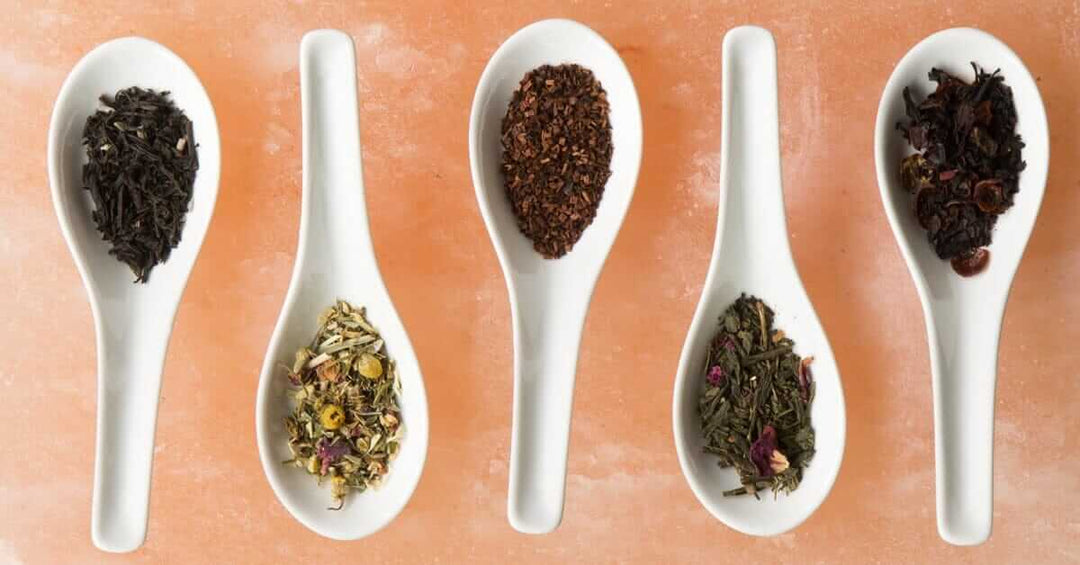 5 white spoons holding different tea varieties