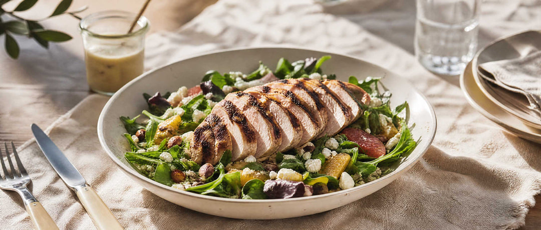 honey mustard grilled chicken on mixed greens on rustic table up close