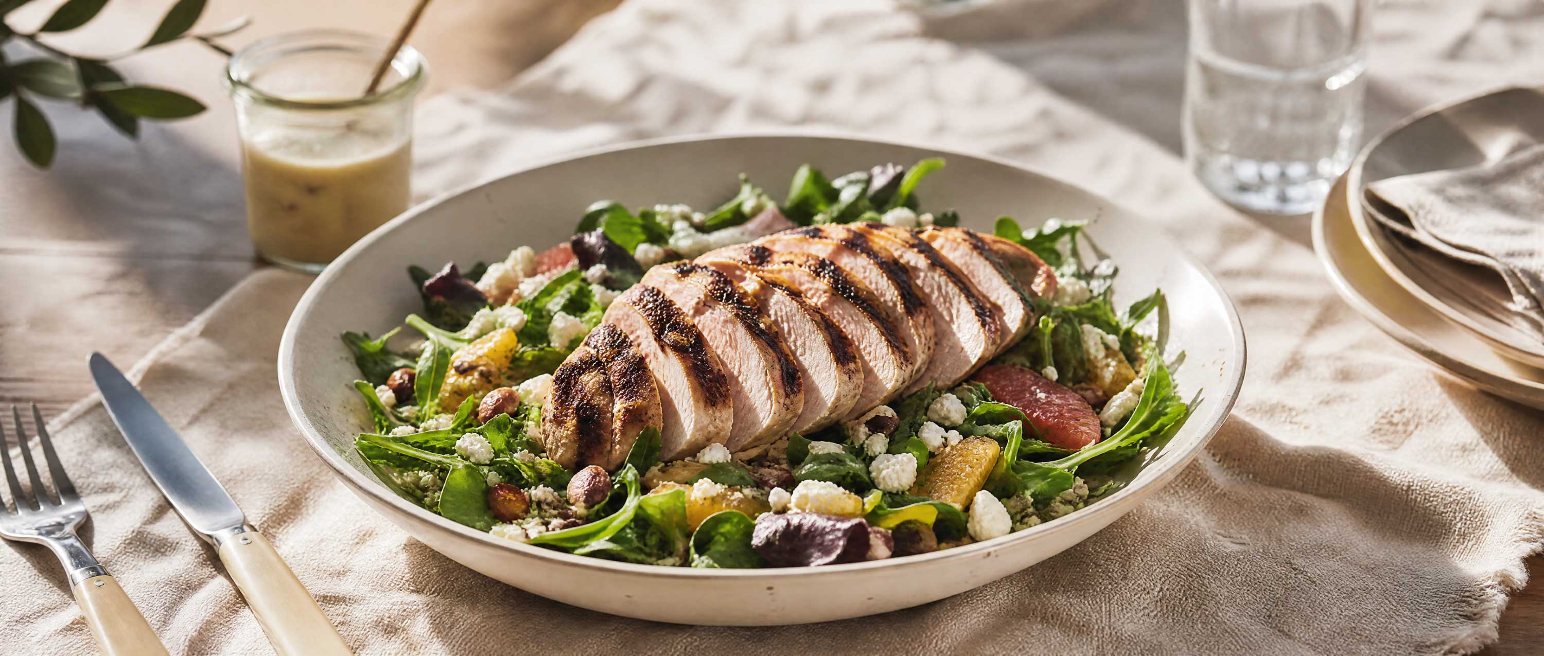 honey mustard grilled chicken on mixed greens on rustic table up close