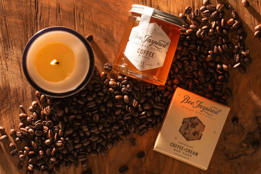 Coffee Honey, Coffee + Cream Bar Soap, and Double Espresso Luxe Candle on a wooden table with coffee beans