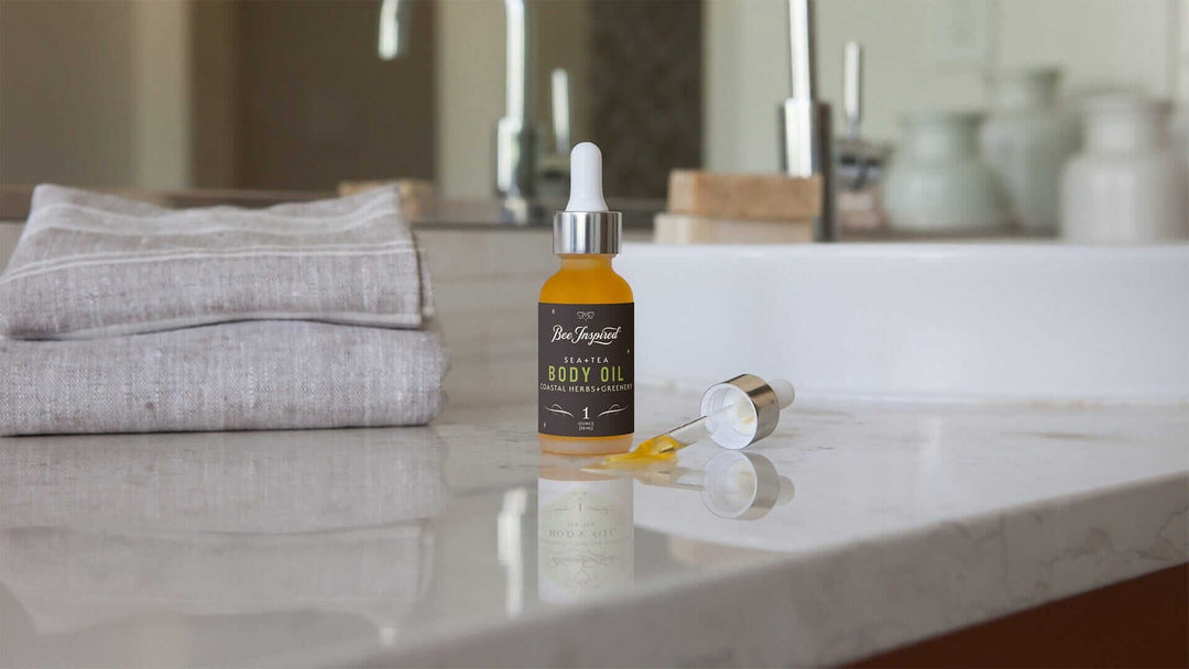 a jar of body oil sits on a marble bathroom counter