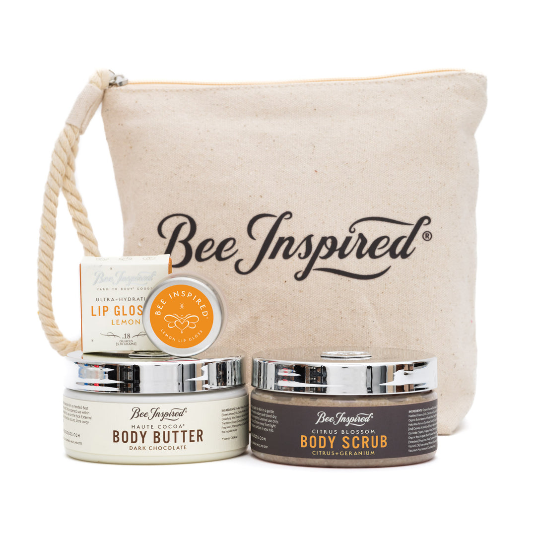 Bee Inspired skincare products including lip gloss, body butter, and body scrub with a canvas bag on a white background.