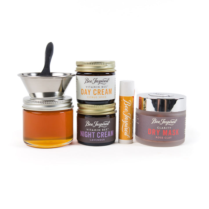 Collection of Bee Inspired skincare products including jars and bottles on a white background
