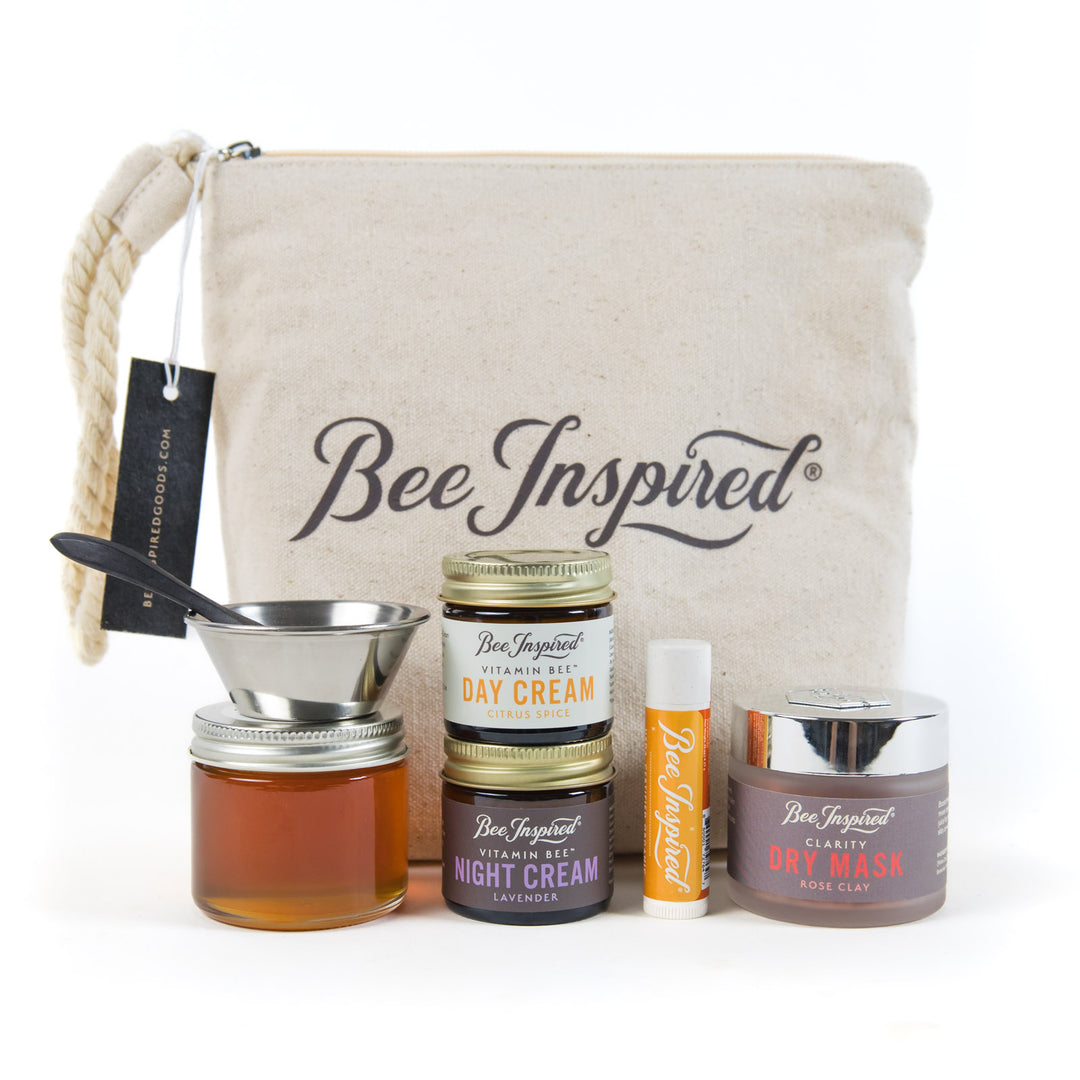 Bee-Inspired skincare products including jars, a cream stick, and a pouch on a white background