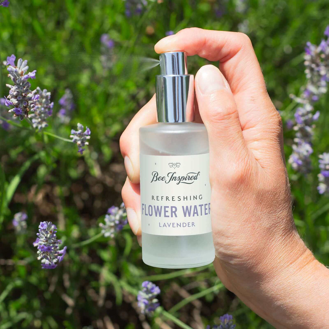 Someone spraying Bee Inspired lavender flower water next to lavender field 