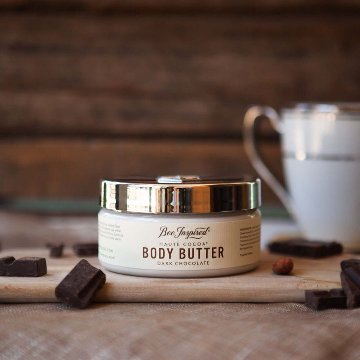 Bee Inspired Haute Cocoa Body Butter surrounded by pieces of chocolate
