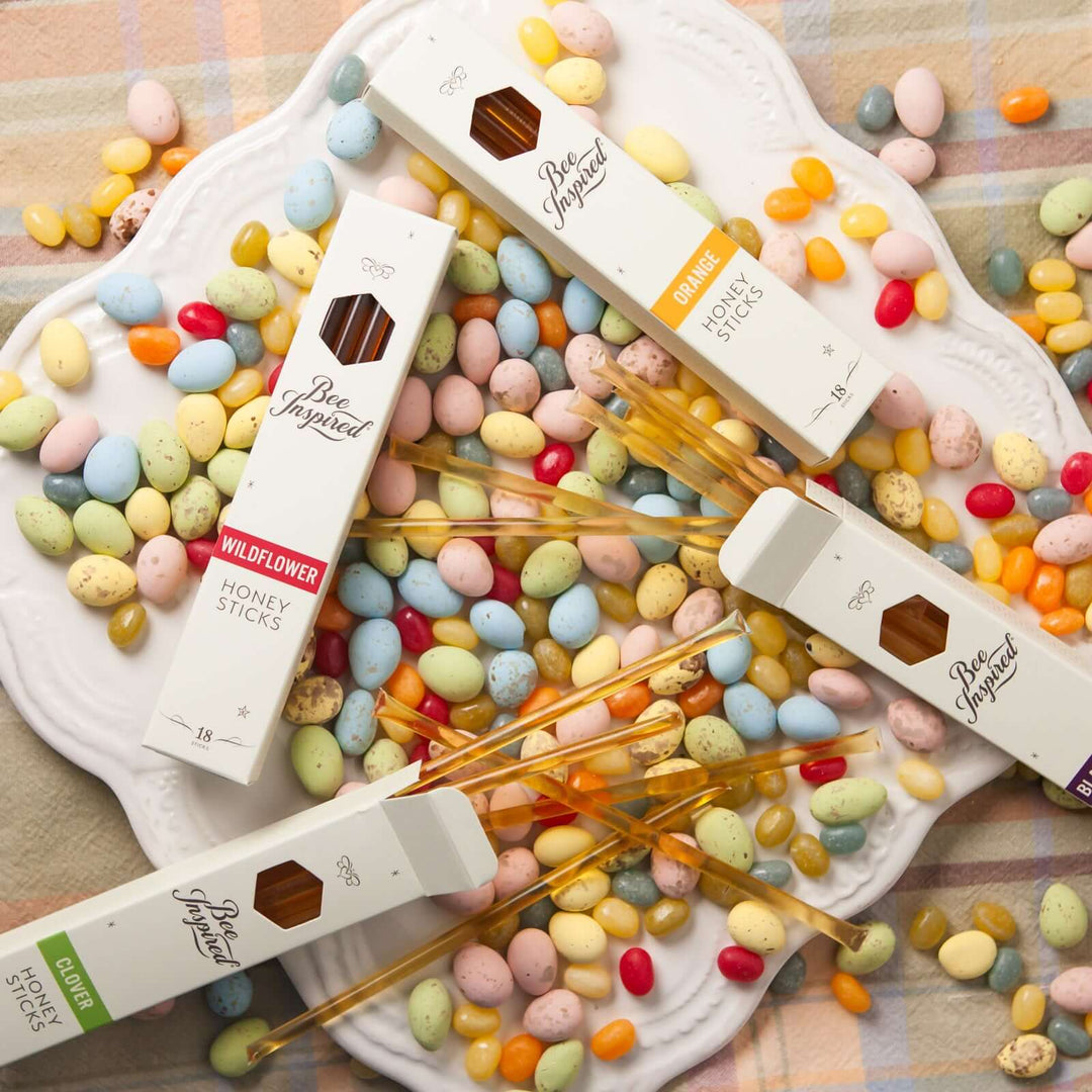 Boxes of varietal honey sticks on a plate of multicolored jelly beans 