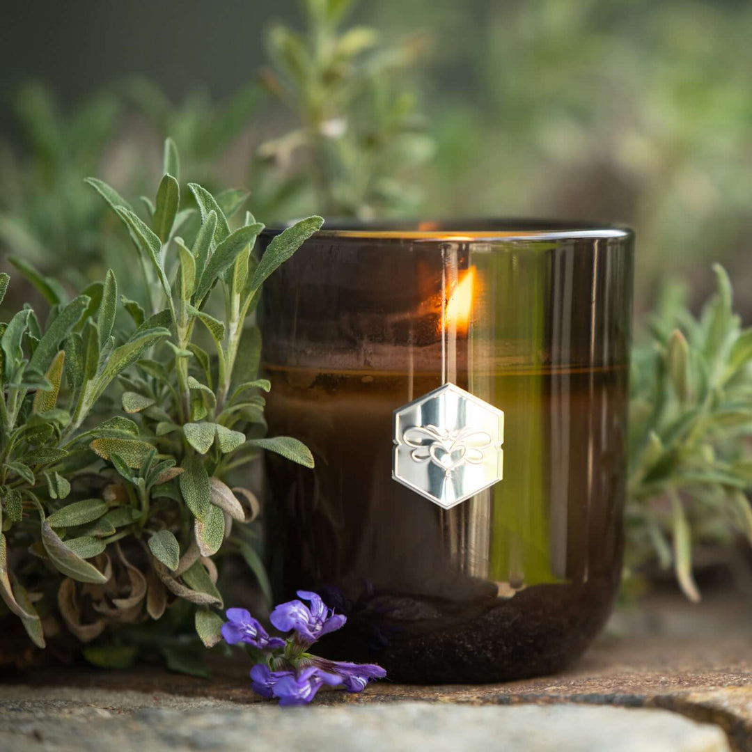 Luxe candle burning next to sage 