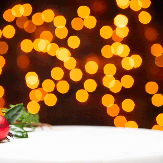 Short animation of three mini luxe candles in front of holiday lights 