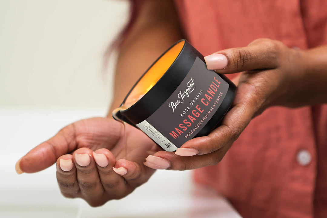 woman pouring rose garden massage candle oil into her hand