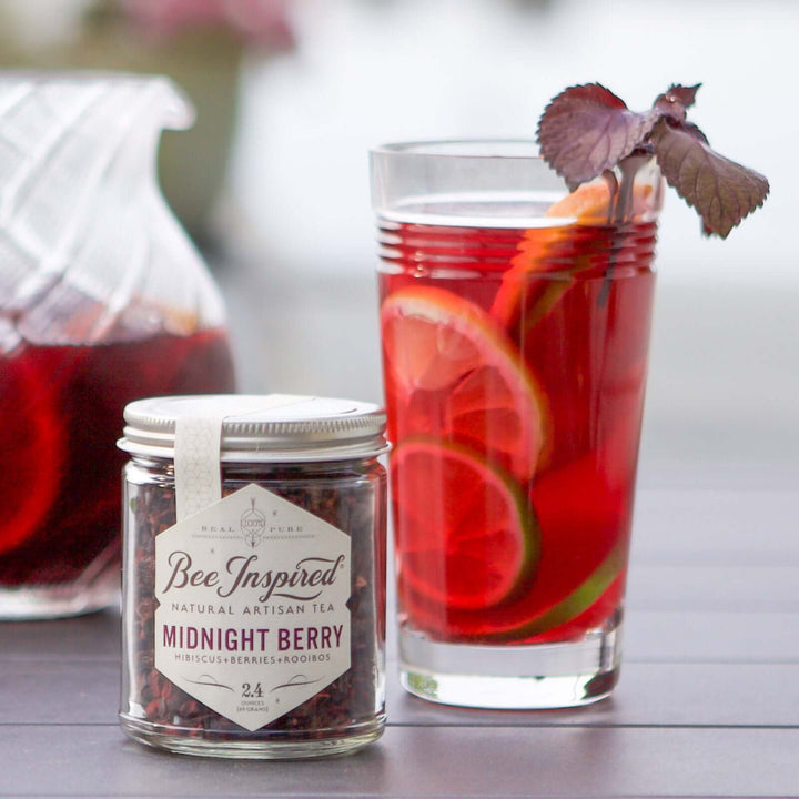 Midnight Berry Tea jar next to tall iced tea glass with garnish