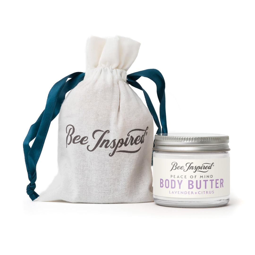 Body butter jar with 'Bee Inspired' text and a matching drawstring bag on a white background