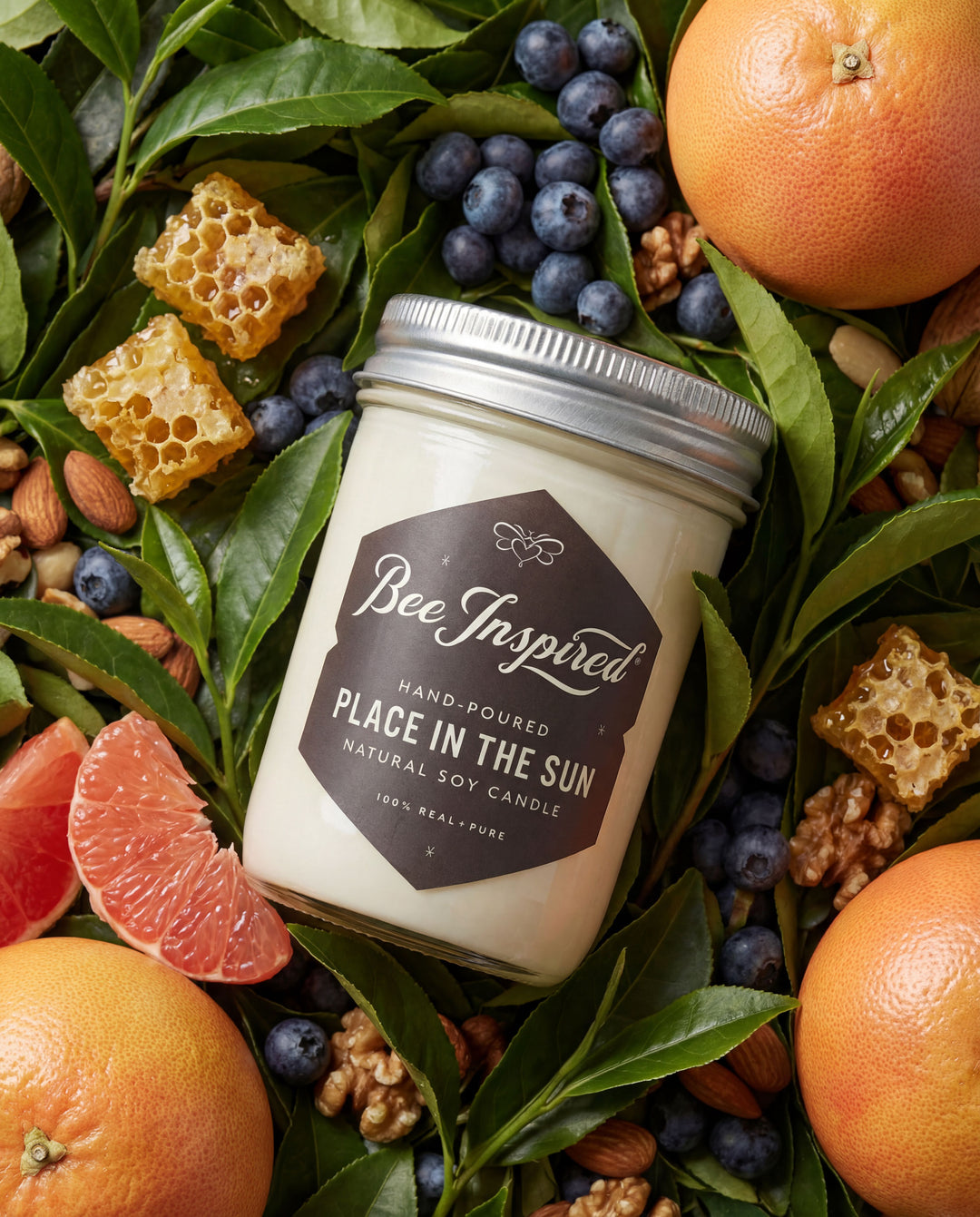 Bee-Inspired candle surrounded by fruits and honeycomb on a green leafy background