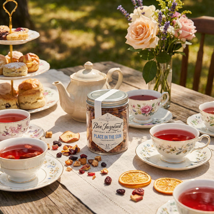 Tea party setup with tea cups, teapot, and a jar of &