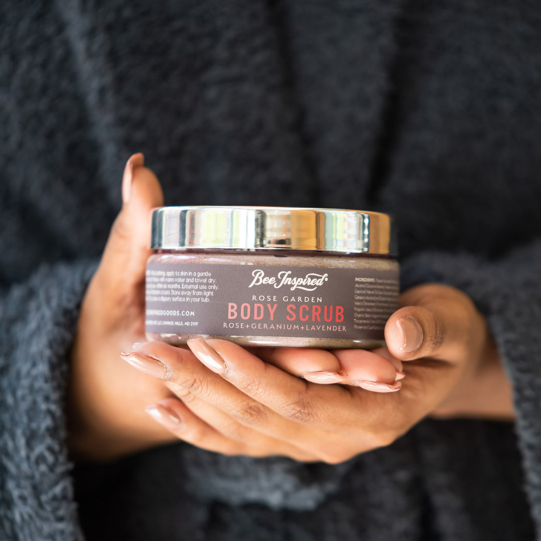 Person holding a jar of Body Scrub with a dark background