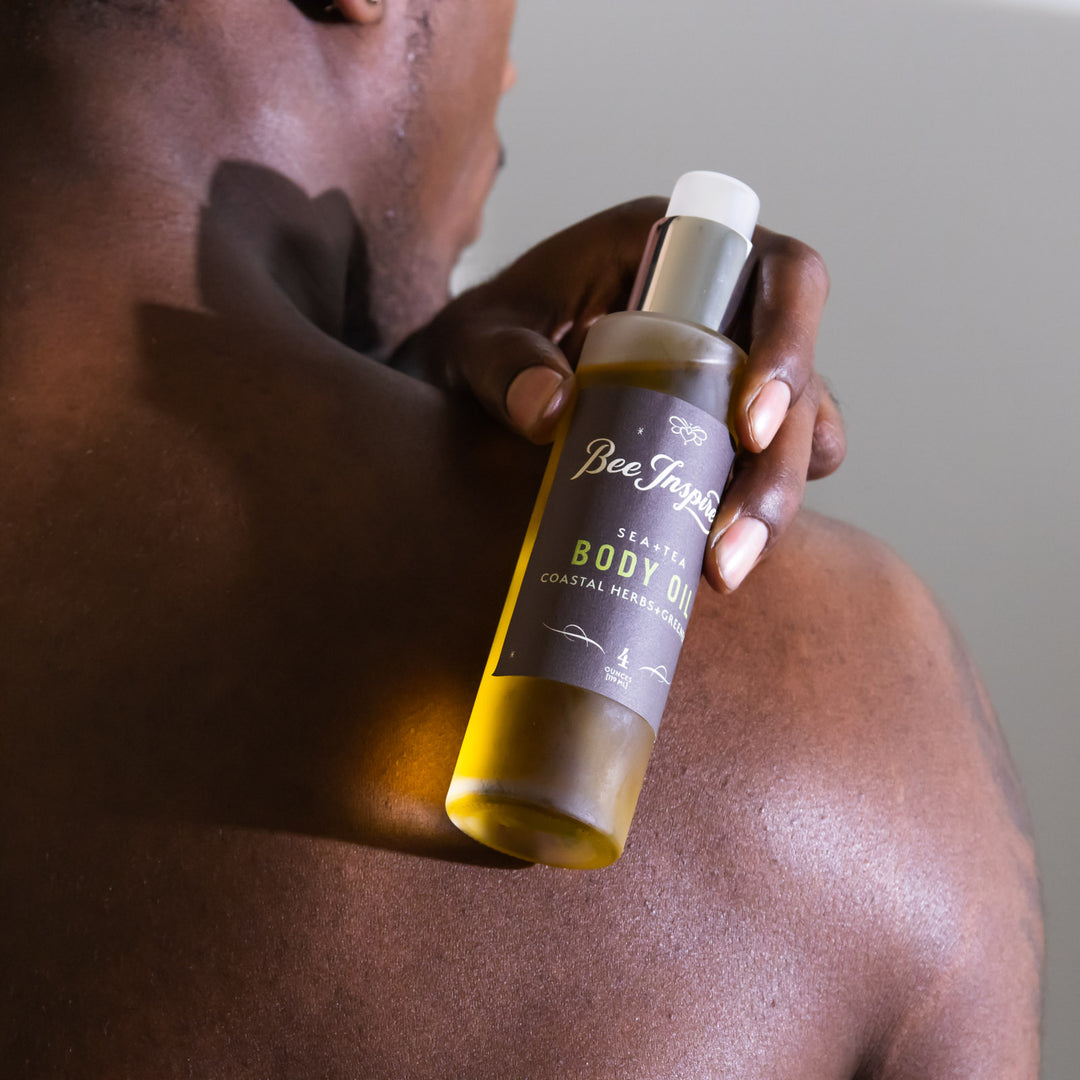 Person applying sea + tea body oil to their shoulder