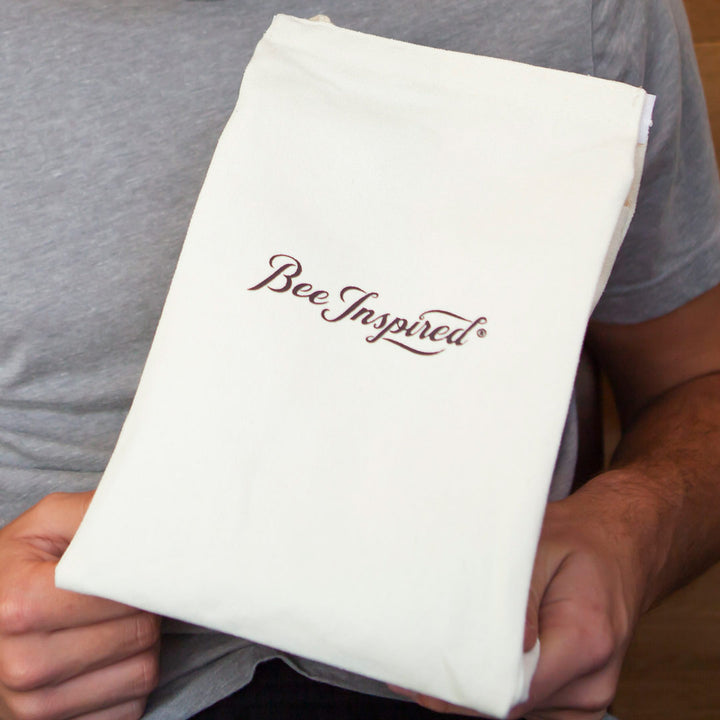 Person holding a white velcro tote bag with &