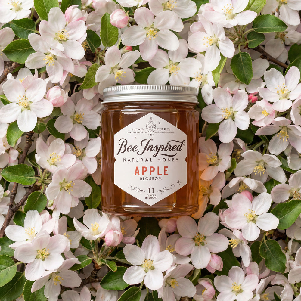 Jar of 'Bee Inspired' natural honey surrounded by apple blossoms