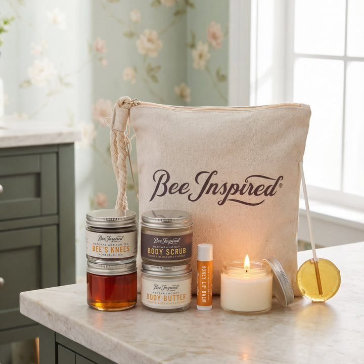 Bee-inspired skincare products including candles and jars on a marble surface with a floral wallpaper background.