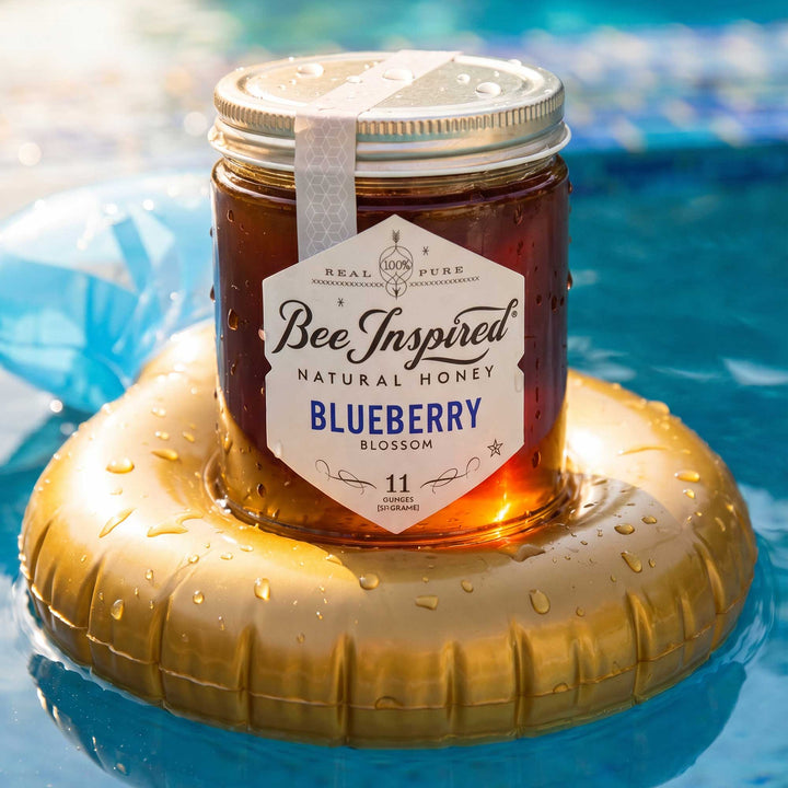 Jar of Bee Inspired Blueberry Blossom honey on a gold inflatable ring in water