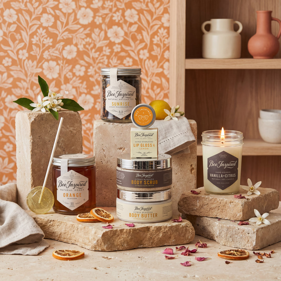 Collection of Bee Inspired skincare products on a wooden surface with a floral-patterned wall in the background.