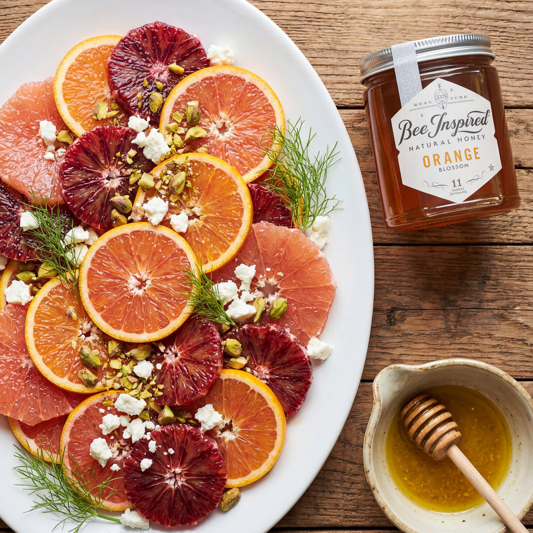 Assorted citrus fruit platter with a jar of honey on a wooden table