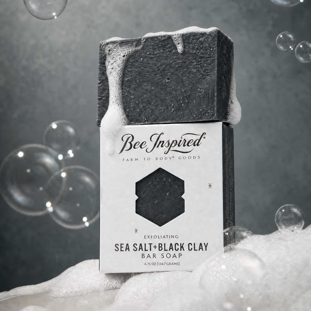 Sea salt and black clay soap on a pile of suds with bubbles in the backgournd