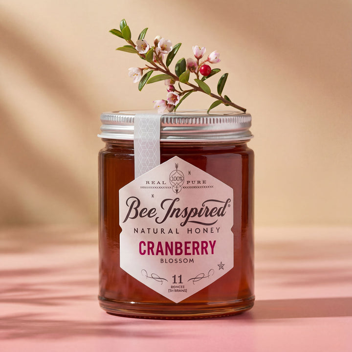 Jar of Bee Inspired Natural Honey Cranberry Blossom on a beige background