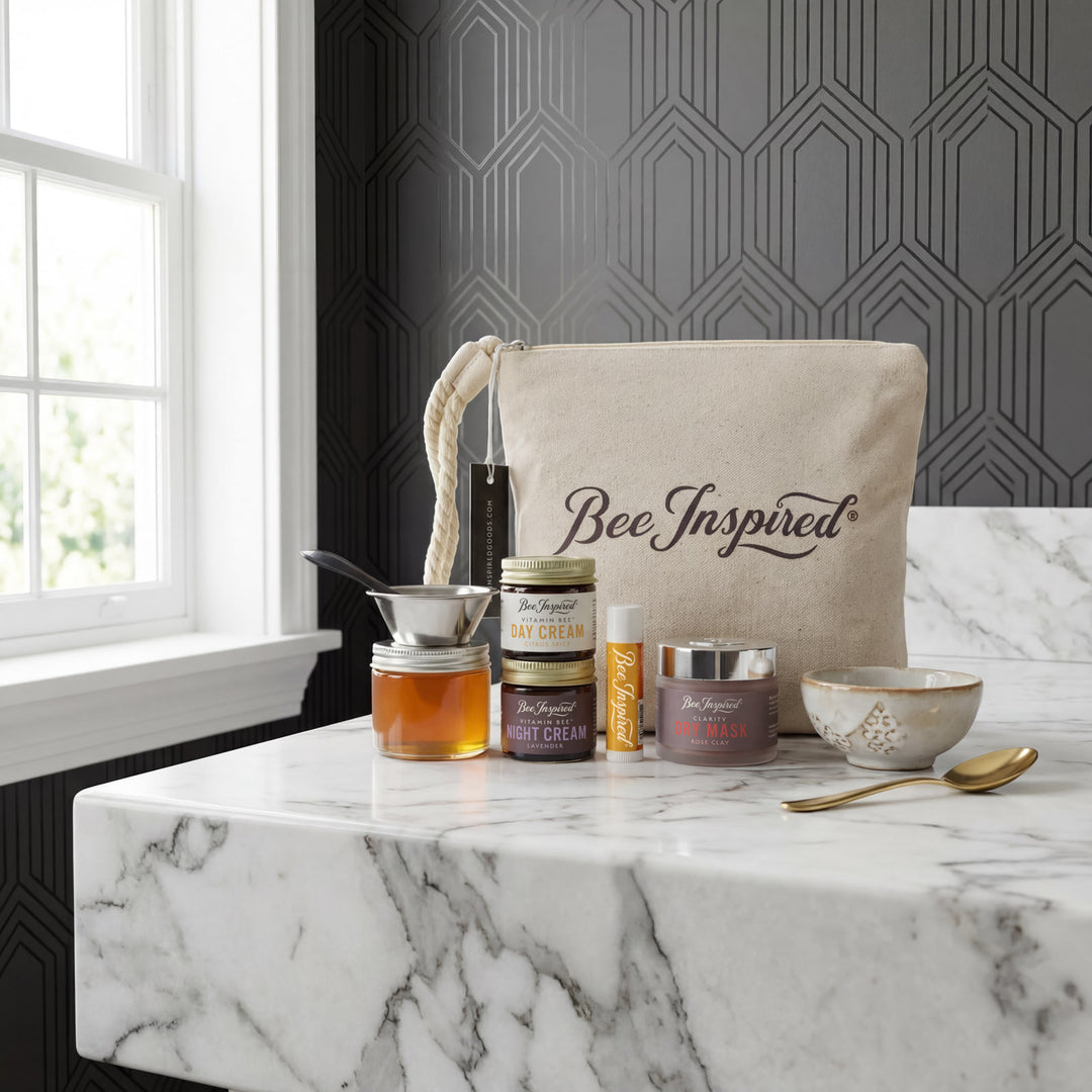 Bee-inspired products on a marble surface with a decorative wall in the background