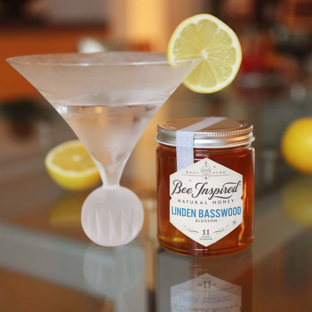 linden basswood honey from bee inspired honey retail store in owings mills next to a drink in a martini glass garnished with a lemon slice