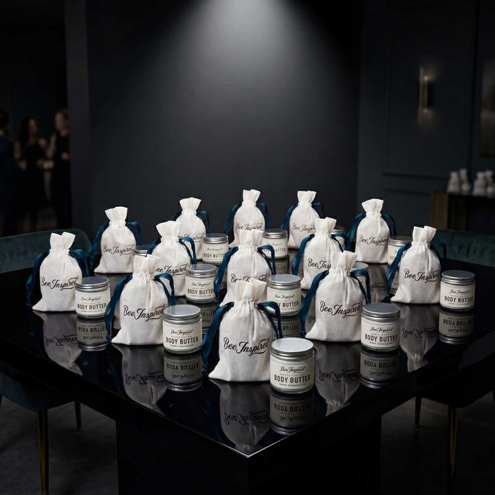Table display of body butter jars and bags with visible branding on a dark surface.