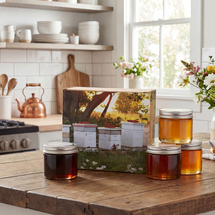 Jars of honey on a kitchen counter with a box featuring bee hives.