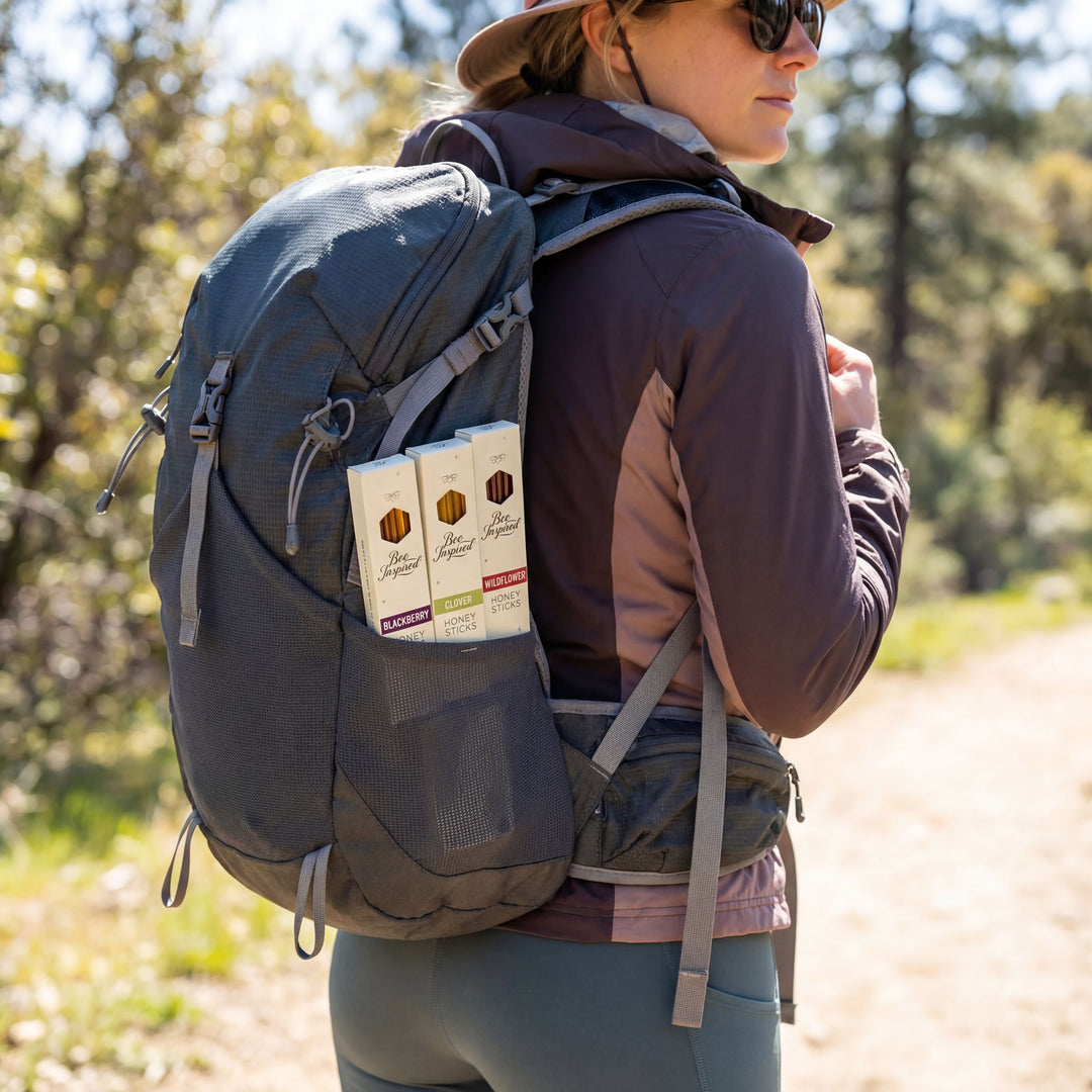 Person hiking outdoors with honey sticks packed in their bag for on-the-go natural fueling.