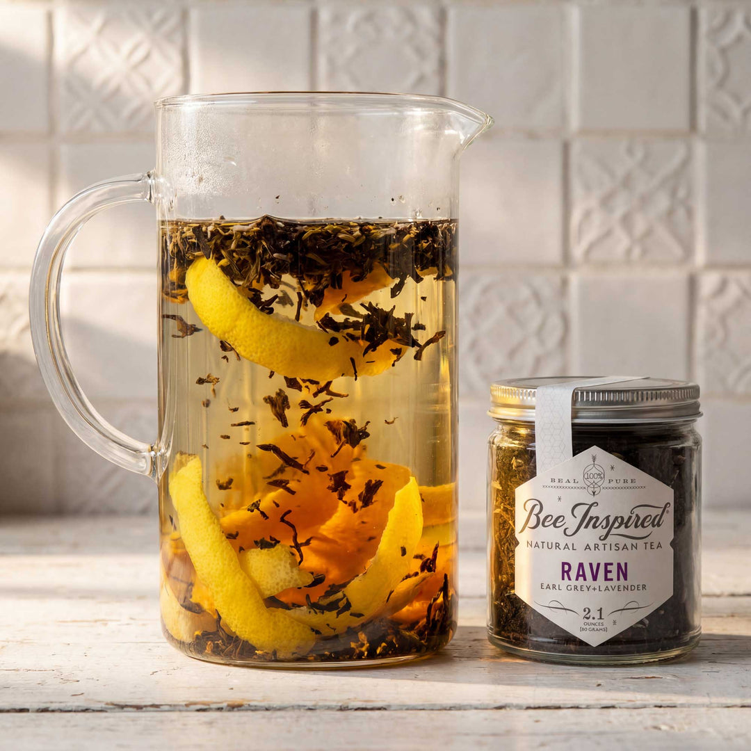 Clear pitcher with iced tea and lemon slices next to a jar of &