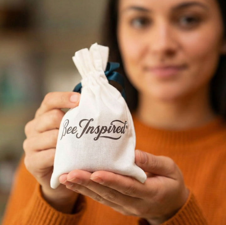 Person holding a white drawstring bag with &