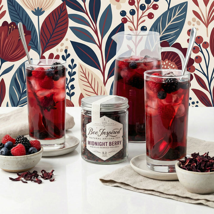 Two glasses of iced berry tea with a jar of &