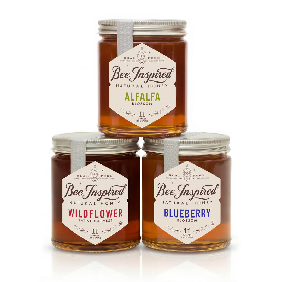 Three jars of 'Bee Inspired' honey with different flavors on a white background