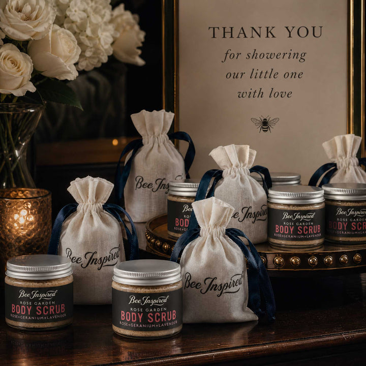 Bee Inspired body scrub party favors with drawstring bags on a decorative table.