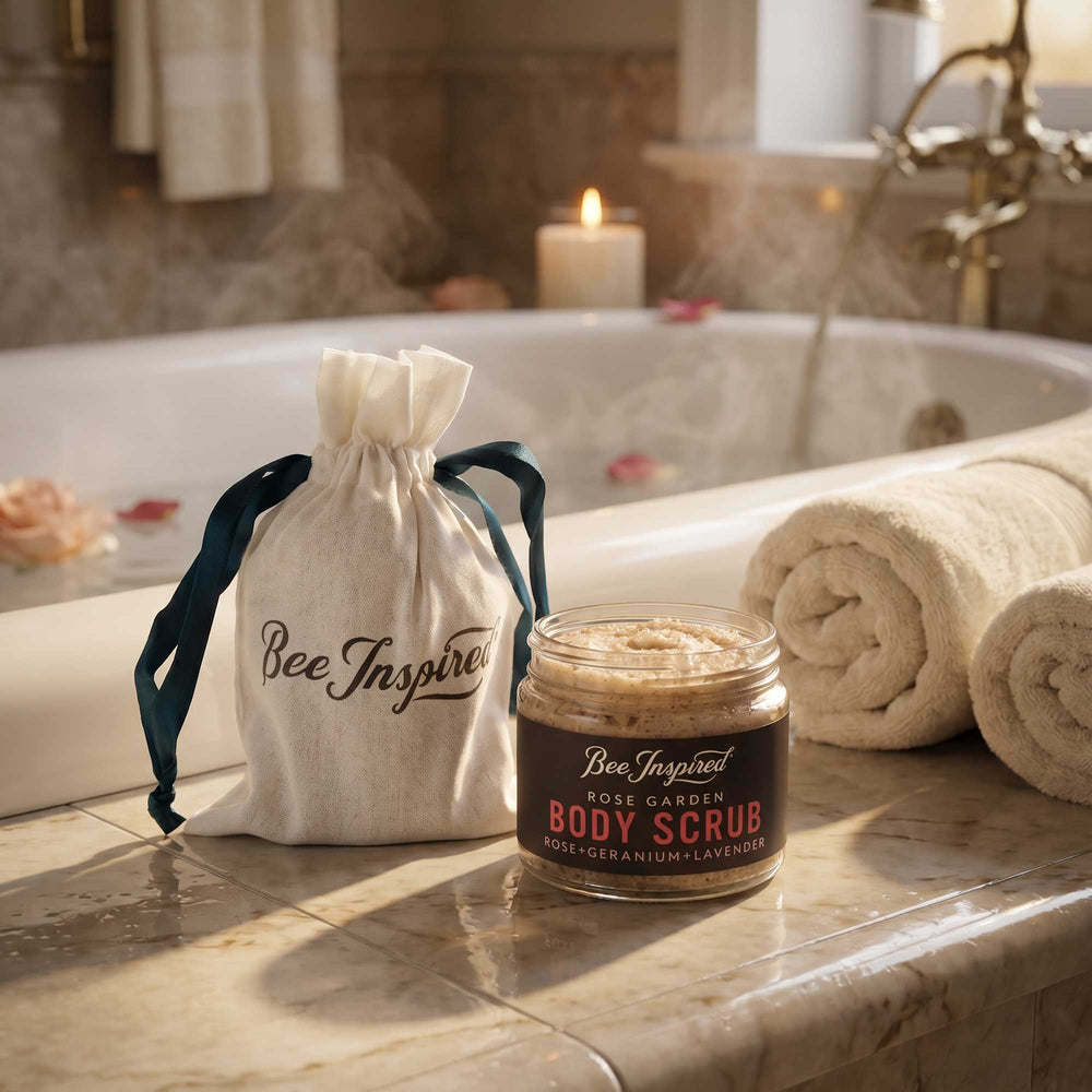 Rose Garden Body scrub party favor with 'Bee Inspired' drawstring bag on a bathroom counter.