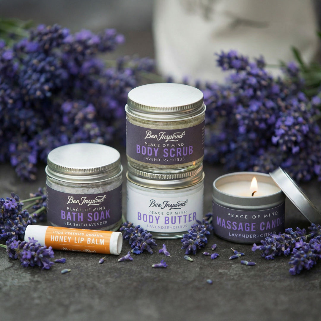Collection of Bee Inspired self-care products with lavender flowers on a dark surface