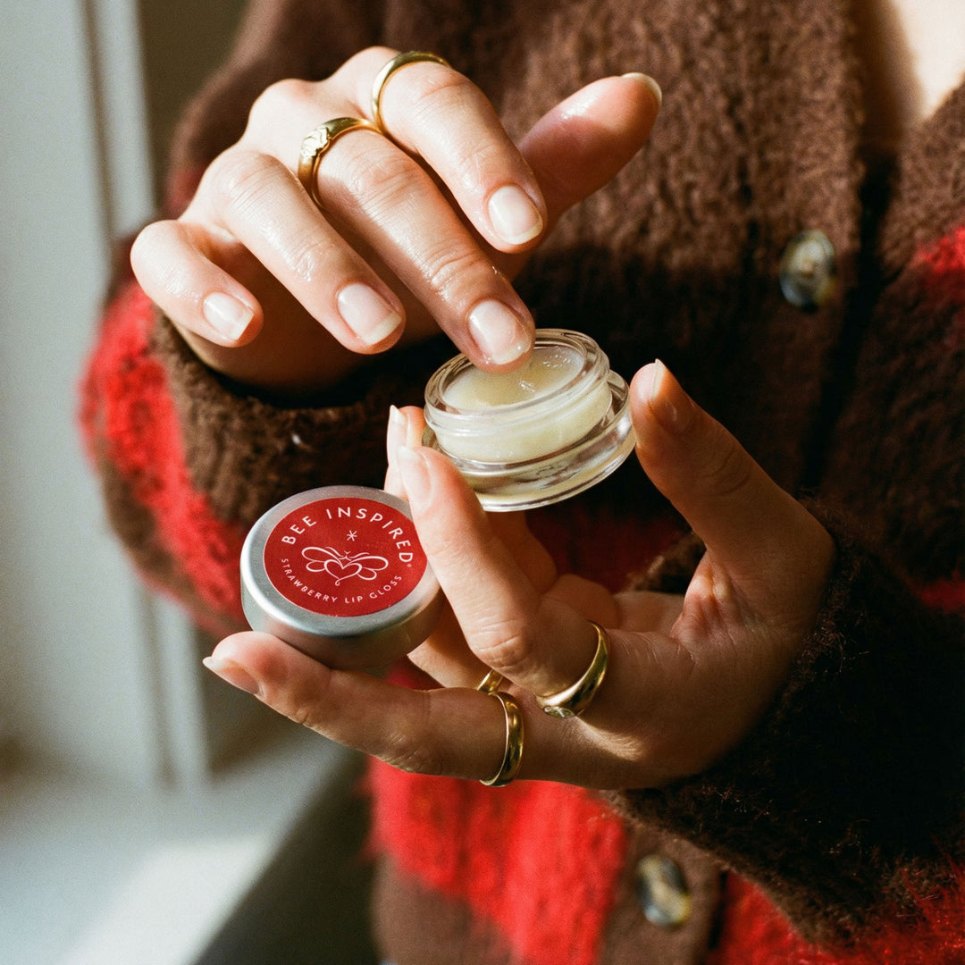 Person holding two lip balm containers with &