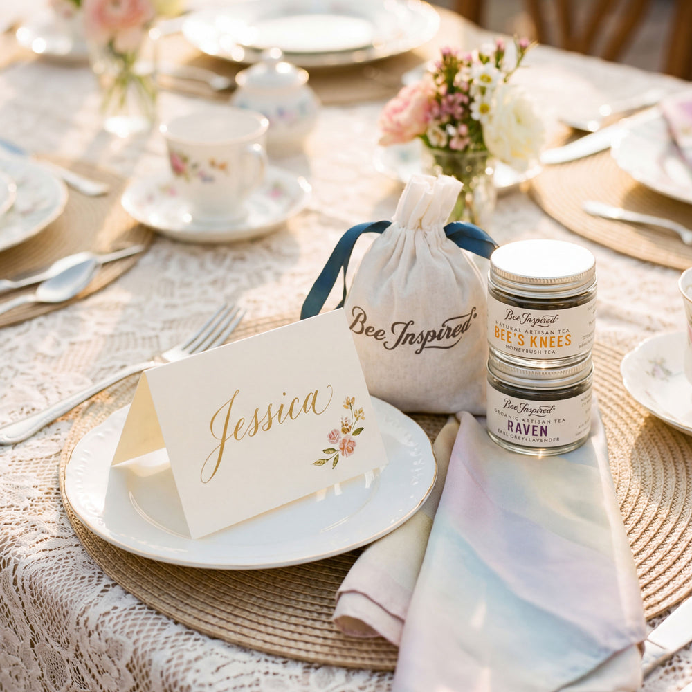 Table setting with 'Bee Inspired' products and a name card on a lace tablecloth.