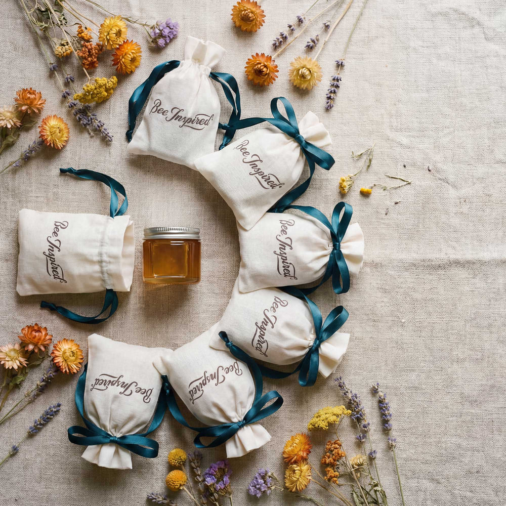 Bee-inspired bags with a jar of honey and flowers on a textured surface